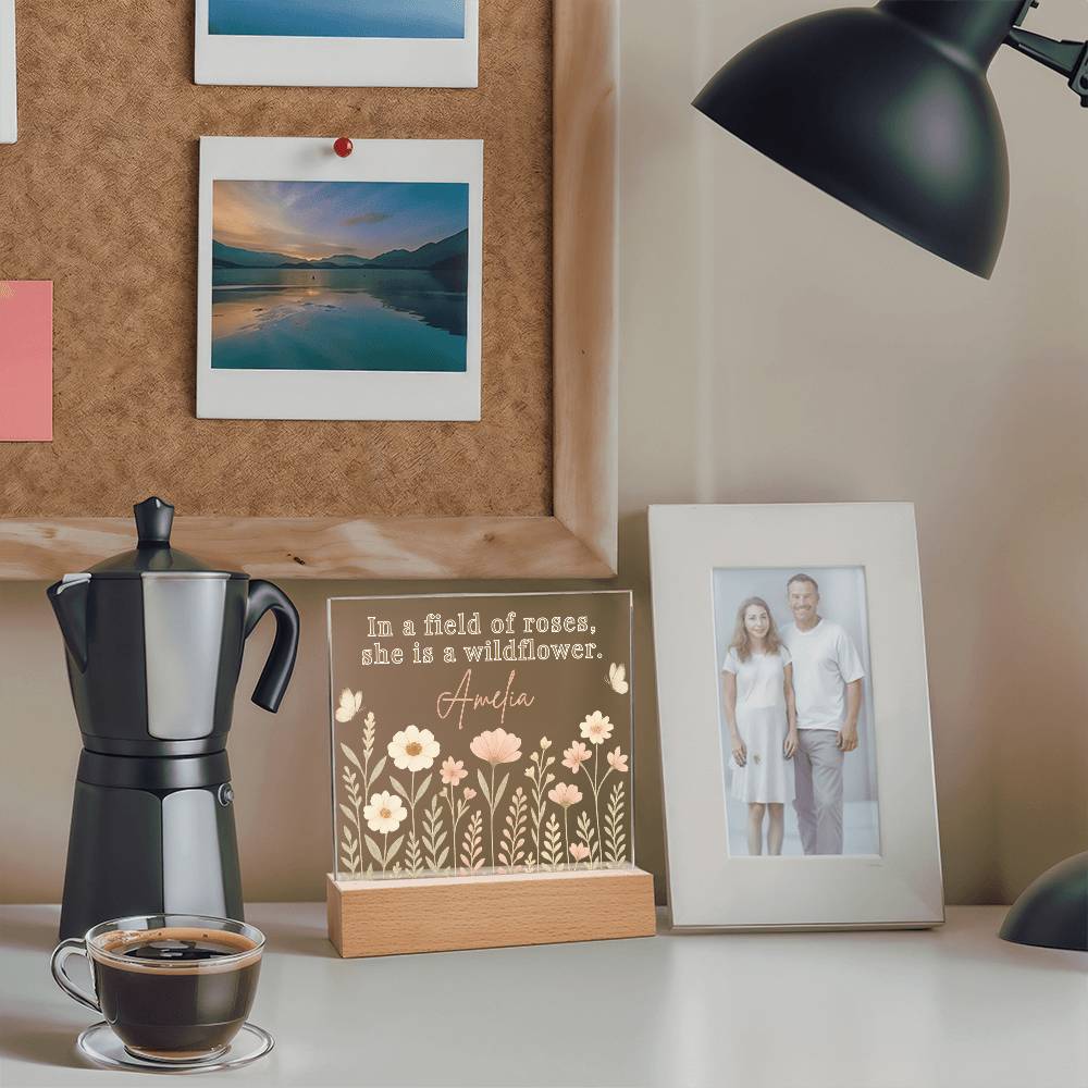 Cafetière, tasse à café, plaque décorative et photo d'un couple sur une surface lisse.